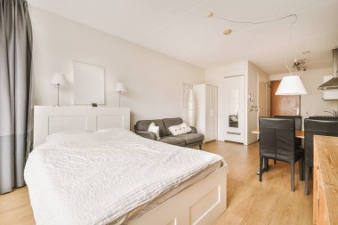 Yatak odasının iç tasarımı, yataklı masa, ahşap gardırop modern dairenin penceresinin kenarına yerleştirilmiş.