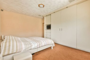 Rahat yatak ve geniş yatak odasında yumuşak halı. İç dekorasyonu çok az.