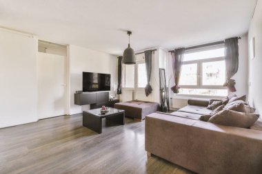 Günümüz minimalist tasarımı. Hafif stüdyo dairesinin ahşap masası ve oturma odası ile beyaz duvarları ve parke zemini arasında yemek masası ve sandalyeleri var.