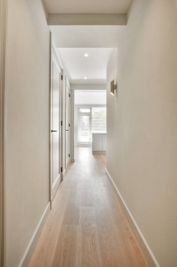 Işık dar koridor, beyaz duvarlarda birçok kapı ve kereste zemininde parlayan lamba