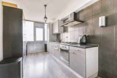 Minimalist tarzı beyaz mobilyalı, lavabolu ve sobalı bir ev mutfağı.