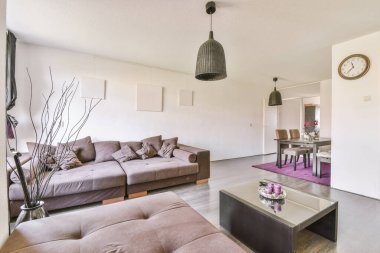 Günümüz minimalist tasarımı. Hafif stüdyo dairesinin ahşap masası ve oturma odası ile beyaz duvarları ve parke zemini arasında yemek masası ve sandalyeleri var.