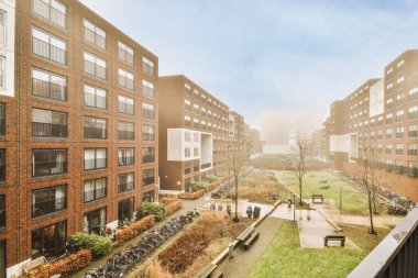 Ağaçlar ve fenerlerle dolu boş bir kaldırım sokağından tuğla evler manzarası