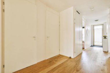 Beyaz duvarlı geniş koridorlu çağdaş dairenin iç mimarisi