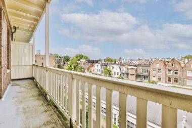 Dar tuğlalı balkon, metal parmaklıklar ve kapı.