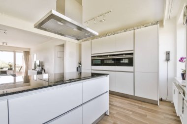 Günümüz minimalist tasarımı. Hafif stüdyo dairesinin ahşap masası ve oturma odası ile beyaz duvarları ve parke zemini arasında yemek masası ve sandalyeleri var.