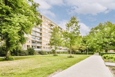 Arabaları, ağaçları ve fenerleri olan boş bir kaldırımdan panorama manzaralı evler.