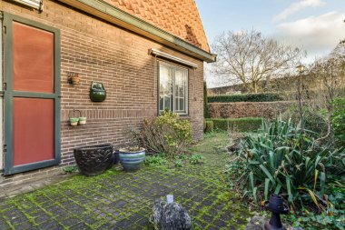 Neat patio with sNeat paved patio with sitting area and small garden near wooden fenceitting area