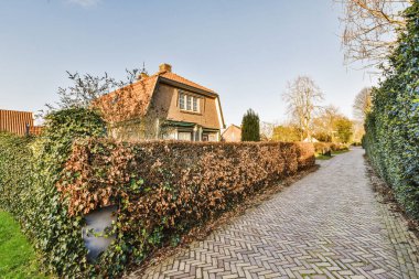 Tabelaları, arabaları, kaldırımları ve ahşap kapıları olan tuğla binanın önü daireye çıkıyor.