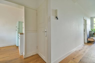 Balkondan balkona açılan bir oda ve tavan kirişli modern evdeki dar koridor.