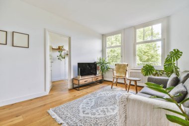 Yastıkları olan rahat bir kanepe. Duvara yaslanmış TV ve dekorasyonlar modern sevgi odasında.