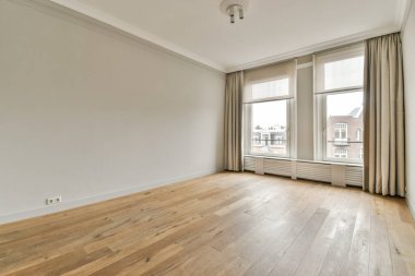 Evdeki boş ışık odasında, beyaz duvardaki plastik pencere ve radyatör.