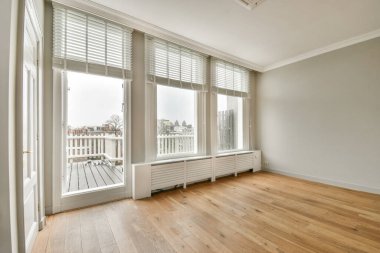 Evdeki boş ışık odasında, beyaz duvardaki plastik pencere ve radyatör.