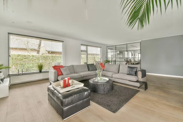 Square table placed on mat near couch and TV in stylish living room of contemporary apartment