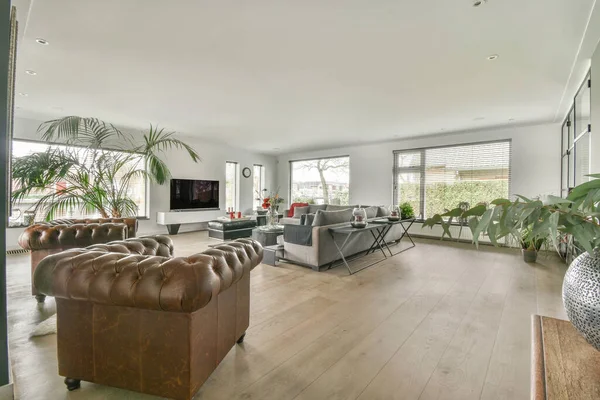 Square table placed on mat near couch and TV in stylish living room of contemporary apartment