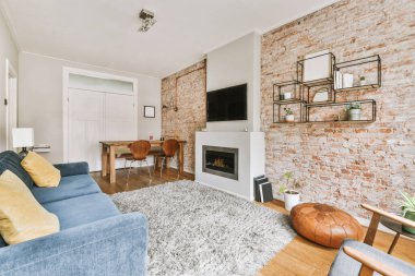 Geniş pencereli, ahşap kanepeli, dolaplı ve televizyonlu modern minimalist oturma odasının iç tasarımı beyaz duvara yerleştirilmiş.