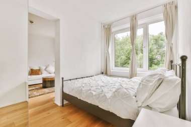 Yatak odasının iç tasarımı, yatak odası ve ahşap gardırop modern dairenin penceresinin kenarına yerleştirilmiş.