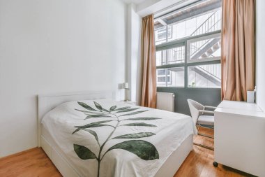 Yatak odasının iç tasarımı, yatak odası ve ahşap gardırop modern dairenin penceresinin kenarına yerleştirilmiş.