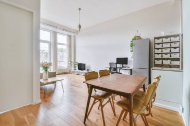 Modern apartmandaki dekorasyonlu ve televizyonlu, rahat koltuğun yanına yerleştirilmiş eski püskü ahşap masa.
