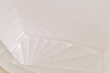 Minimalist iç tasarımı olan modern lüks dairenin ikinci katına çıkan ahşap merdivenli beyaz koridor.