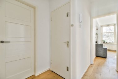 TV 'nin yanındaki koltuklar ve masa, çağdaş apartmandaki geniş odalı yemek alanına karşıdır.