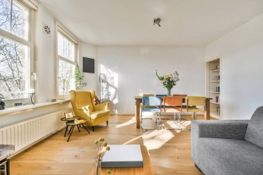 TV 'nin yanındaki koltuklar ve masa, çağdaş apartmandaki geniş odalı yemek alanına karşıdır.