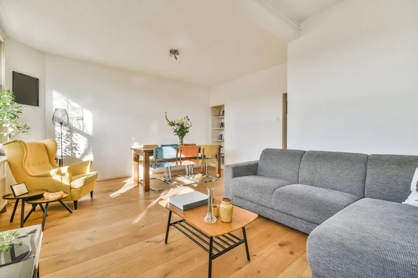 TV 'nin yanındaki koltuklar ve masa, çağdaş apartmandaki geniş odalı yemek alanına karşıdır.