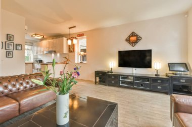 Geniş pencereli, ahşap kanepeli, dolaplı ve televizyonlu modern minimalist oturma odasının iç tasarımı beyaz duvara yerleştirilmiş.