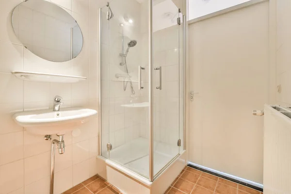 モダンなアパートで 白いトイレとガラスシャワー付きのバスタブ付きのスタイリッシュなバスルームのインテリアデザイン — ストック写真
