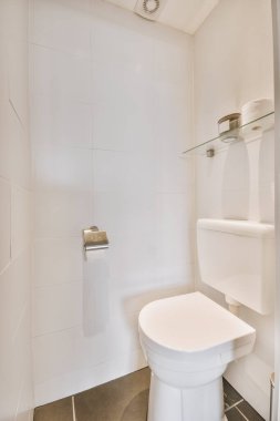 Lavabolu ve duvarlı, beyaz duvarlı ve kareli tuvaletli dar bir tuvalet.