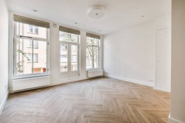 Evdeki boş ışık odasında, beyaz duvardaki plastik pencere ve radyatör.