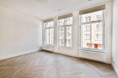 Evdeki boş ışık odasında, beyaz duvardaki plastik pencere ve radyatör.