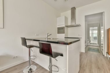 Çağdaş dairenin yemek odasının karşısındaki koltuklar ve masa