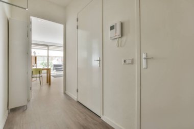 Siyah dolaplı çağdaş apartman koridoru ve terasa açılan kapı.
