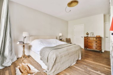 Yatak odasının iç tasarımı, yatak odası ve ahşap gardırop modern dairenin penceresinin kenarına yerleştirilmiş.