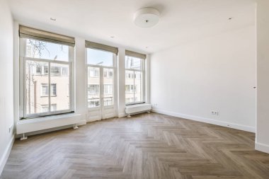 Evdeki boş ışık odasında, beyaz duvardaki plastik pencere ve radyatör.