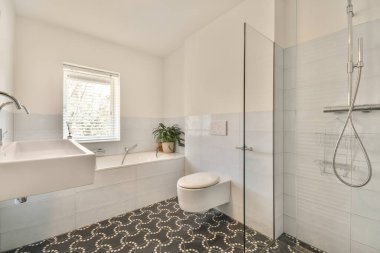 Açık banyo küveti ve duşu olan modern ev iç tasarımı. Tuvaletten bölme duvarıyla ayrılmış.