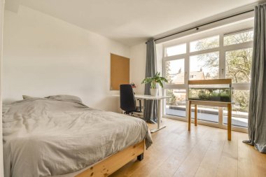 Beyaz duvarları, yumuşak rahat yatağı ve aydınlatmalı minimalist tarzı rafları olan küçük Mansard yatak odasının modern iç tasarımı.