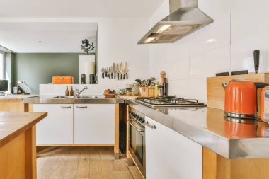 Günümüz minimalist tasarımı. Hafif stüdyo dairesinin ahşap masası ve oturma odası ile beyaz duvarları ve parke zemini arasında yemek masası ve sandalyeleri var.