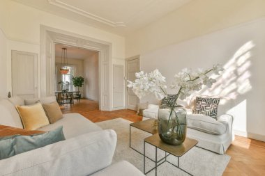 Modern dairenin geniş oturma odasındaki şık mobilyaların üzerinde asılı süslü lamba.