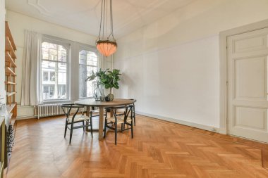 Modern dairenin geniş oturma odasındaki şık mobilyaların üzerinde asılı süslü lamba.