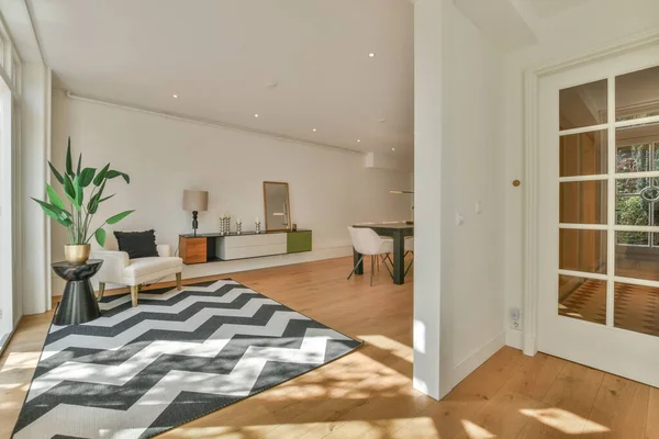 Couches and table located near dining area of spacious room in contemporary apartment