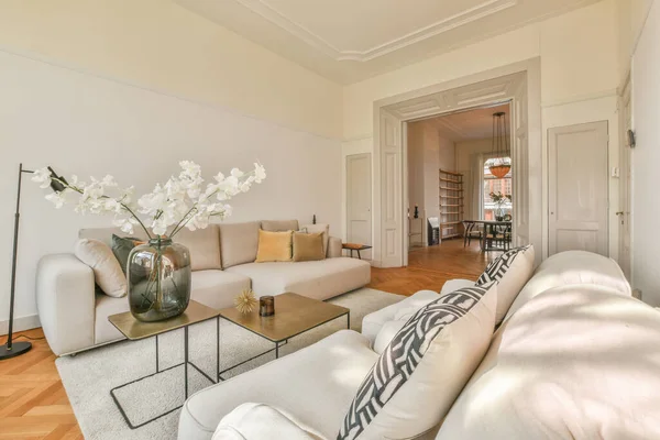 Fancy lamp hanging on ceiling over stylish furniture in spacious living room in modern flat