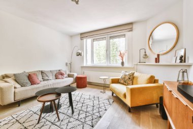 Çağdaş dairenin pencerelerine karşı rahat kanepesi ve televizyonu olan oturma odası.