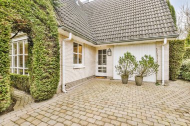 Arabaları, ağaçları ve fenerleri olan boş bir kaldırımdan panorama manzaralı evler.