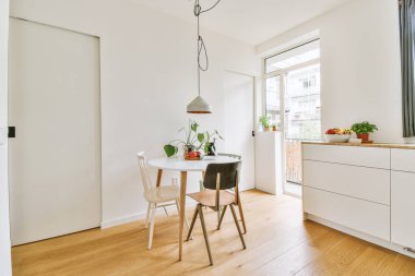 Minimalist tarzı açık mutfağı ve masa ve sandalyeleri olan geniş yemek alanı olan modern çatı katı dairesinin ev tasarımı.