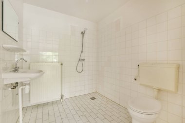 Modern sifon tuvaleti ve seramik lavabo aynanın yanındaki beyaz fayanslı duvarlara ve evdeki küçük tuvaletteki havluya monte edildi.