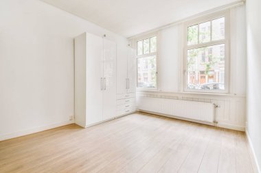 Evdeki boş ışık odasında, beyaz duvardaki plastik pencere ve radyatör.