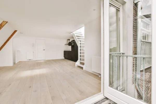 窓や木製の寄木細工の床と空の白いキッチンのインテリア — ストック写真