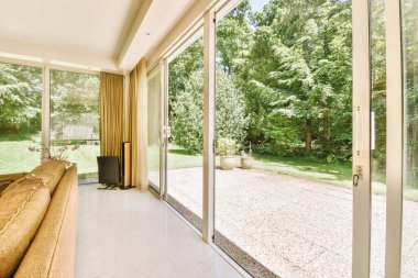 Çağdaş dairenin pencerelerine karşı rahat kanepesi ve televizyonu olan oturma odası.